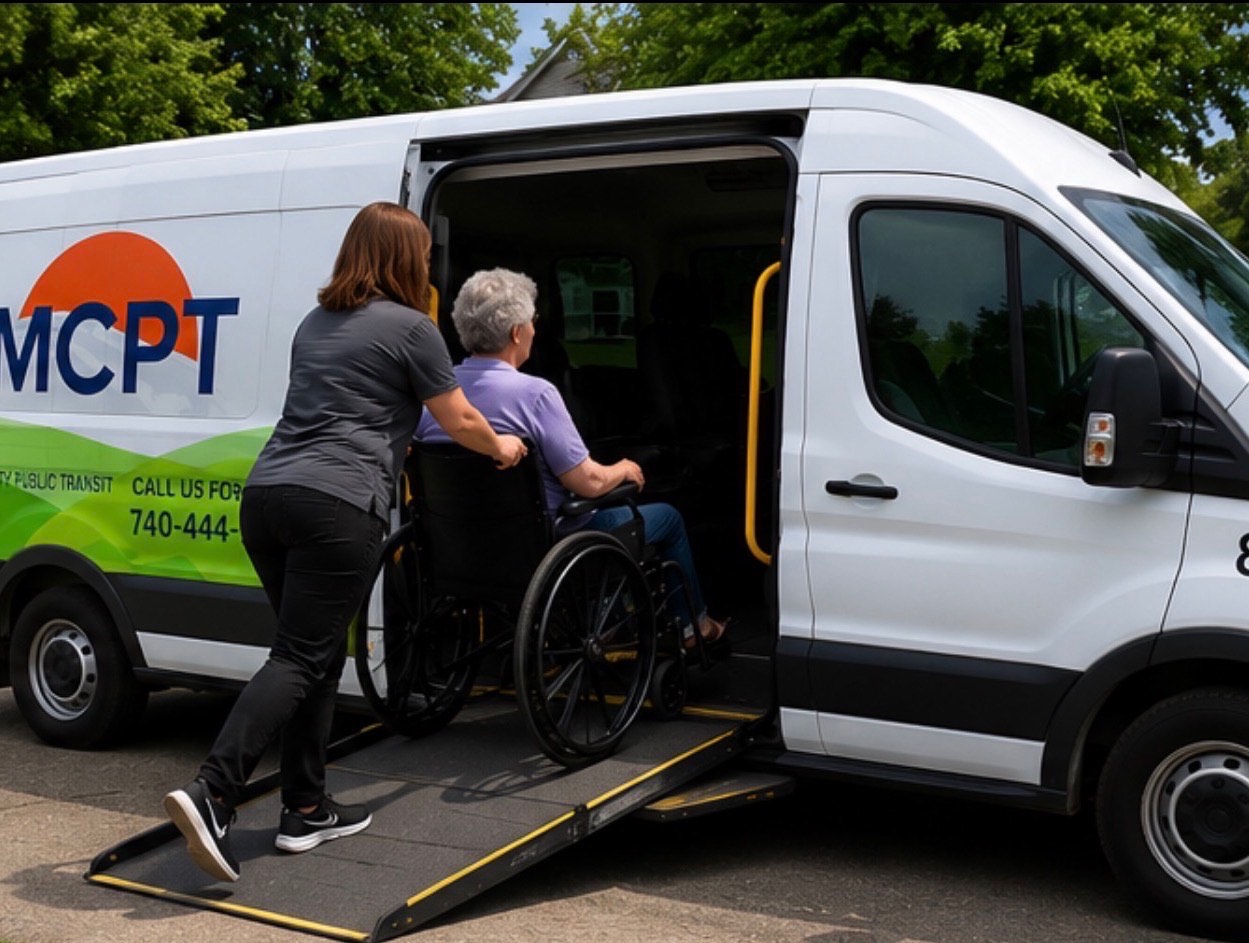 An MCPT driver assisting a rider using a wheelchair onto the vehicle ramp